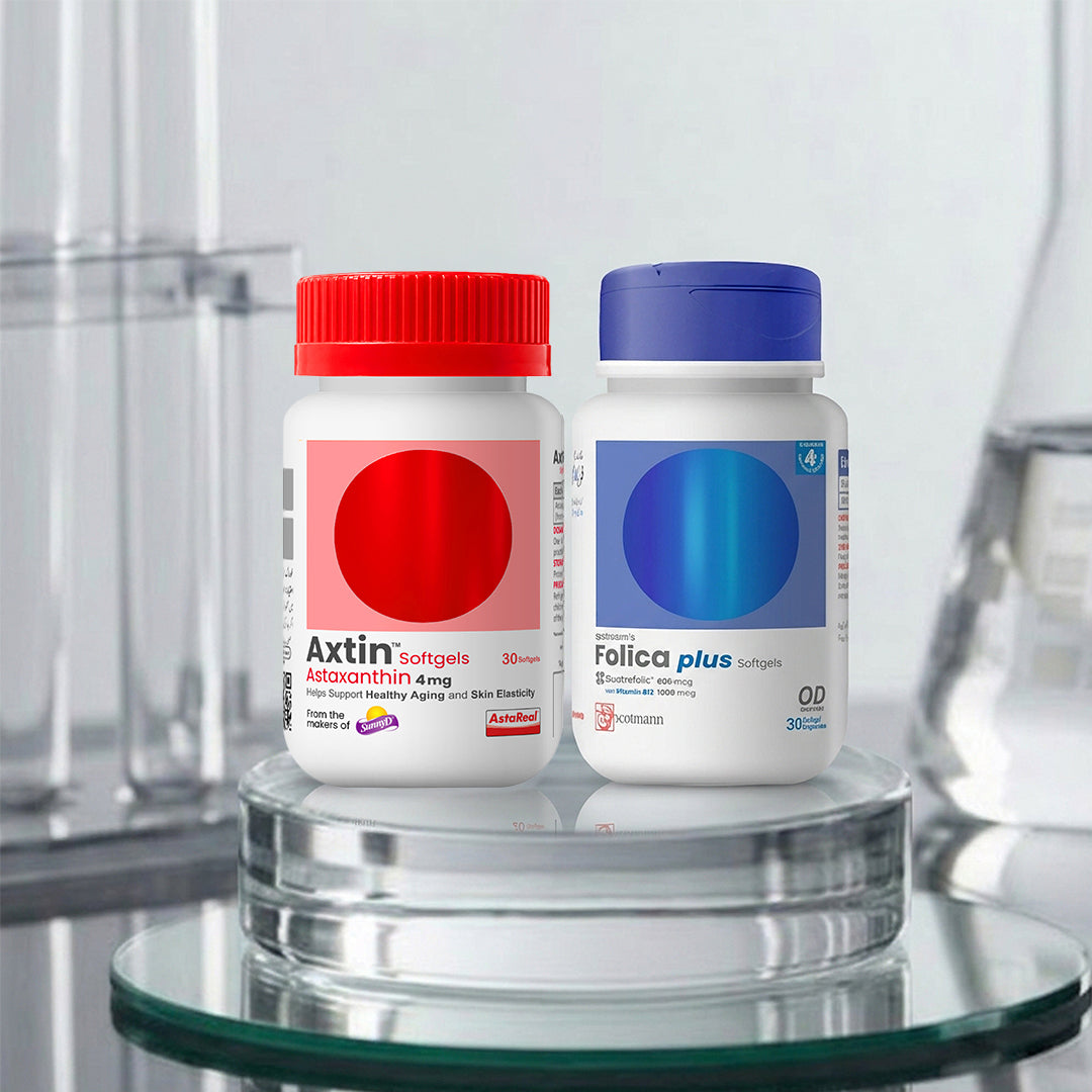 Two supplement bottles displayed on a glass stand: Axtin Softgels with a red cap and red circular label, and Folica plus with a blue cap and blue circular label, set against a blurred laboratory background.
