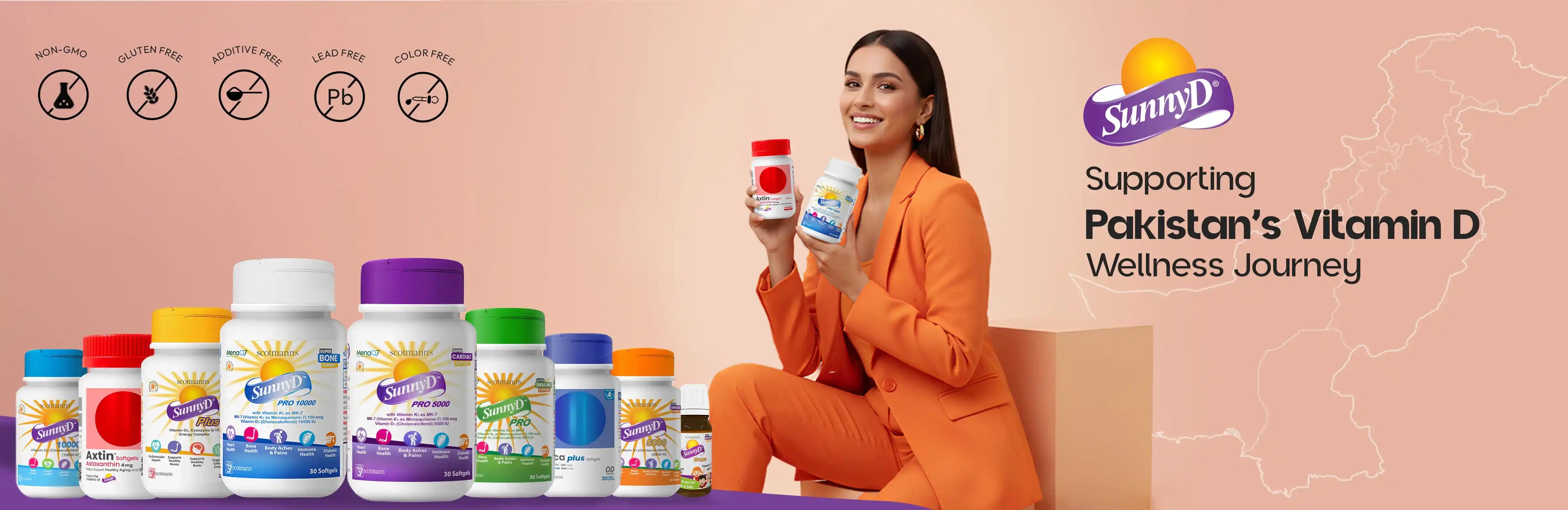 A promotional banner for SunnyD Vitamin D products, featuring a woman in an orange suit holding a bottle, with multiple colorful supplement bottles lined up on the left and text reading 'Supporting Pakistan's Vitamin D Wellness Journey' on the right.